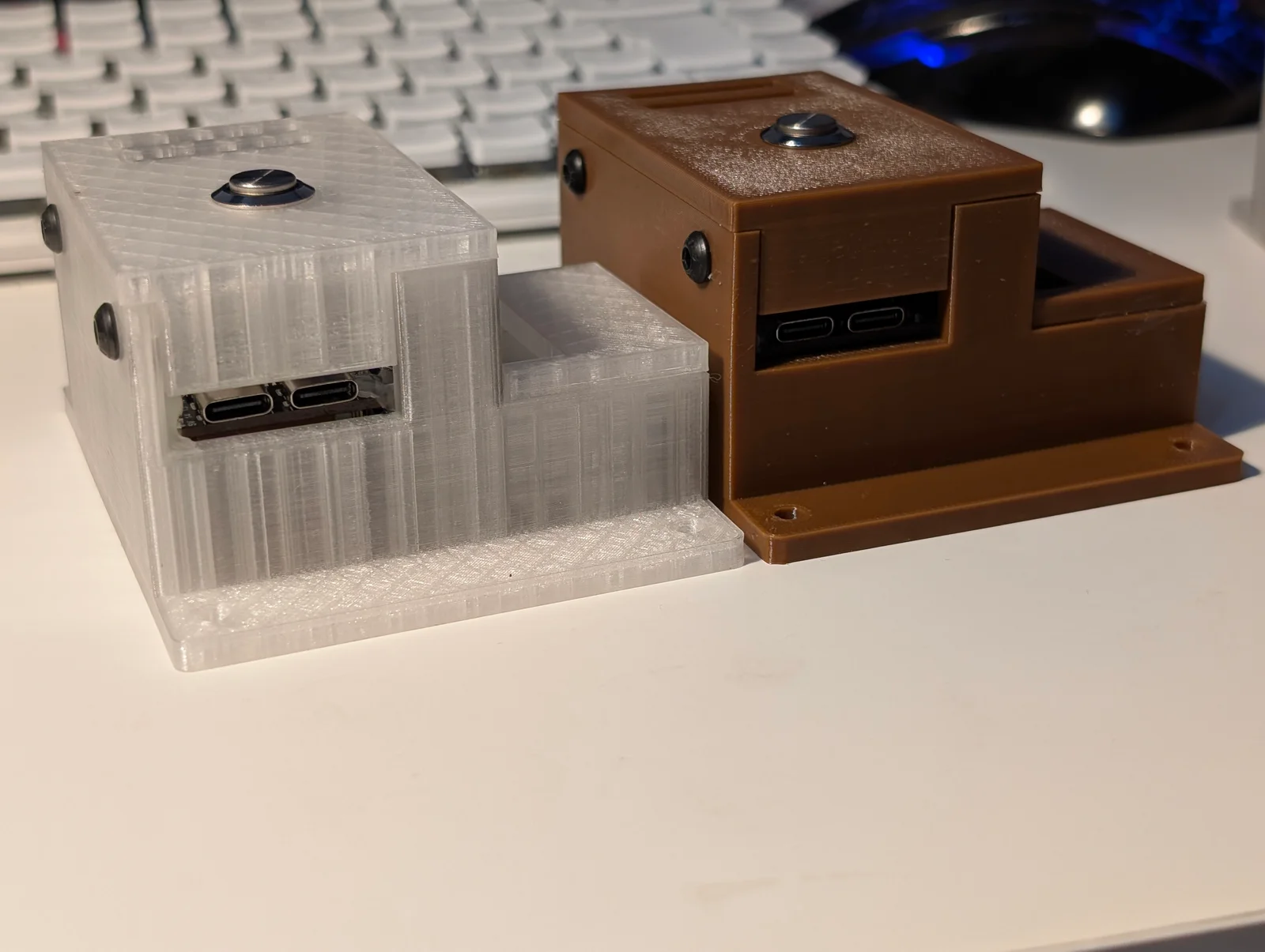 Two completed enclosures viewed from the side, showing access to both USB-C ports and the external setup buttons